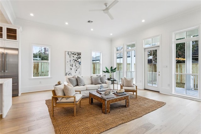 living room featuring crown molding, ceiling fan, light hardwood / wood-style floors, and a wealth of natural light