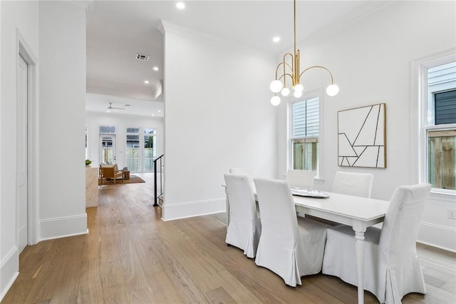 dining space featuring a notable chandelier, crown molding, and light hardwood / wood-style flooring