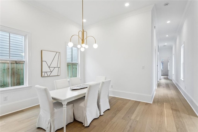 dining area featuring crown molding, a healthy amount of sunlight, and light hardwood / wood-style flooring