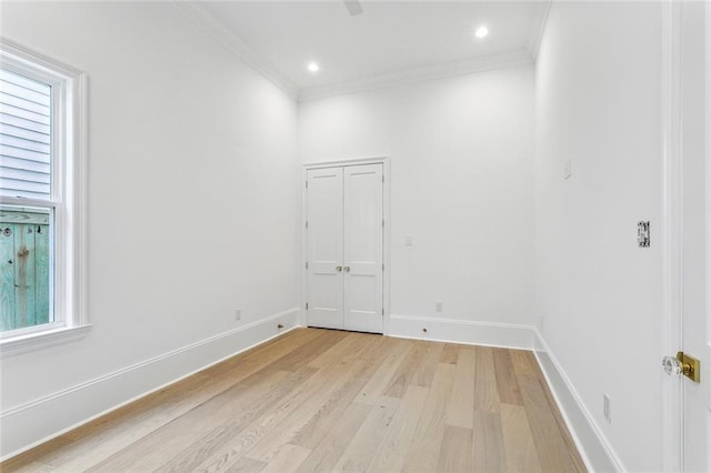 empty room featuring ornamental molding and light wood-type flooring