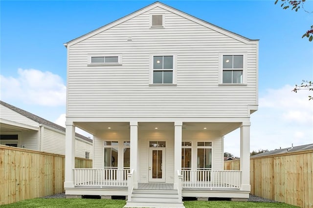 back of property featuring a wooden deck and a lawn