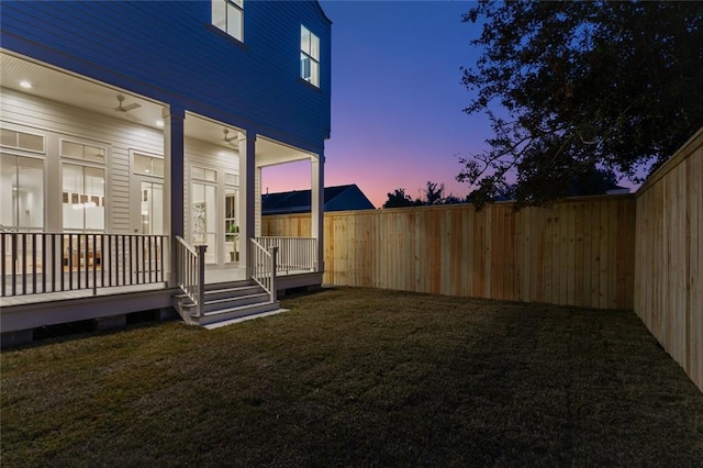 yard at dusk featuring a wooden deck