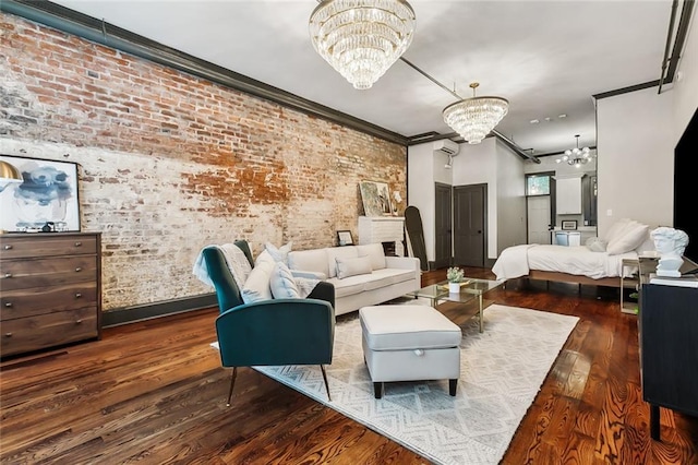 bedroom with dark wood-type flooring, a chandelier, an AC wall unit, ornamental molding, and brick wall