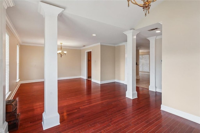 interior space featuring wood finished floors, visible vents, ornate columns, an inviting chandelier, and ornamental molding