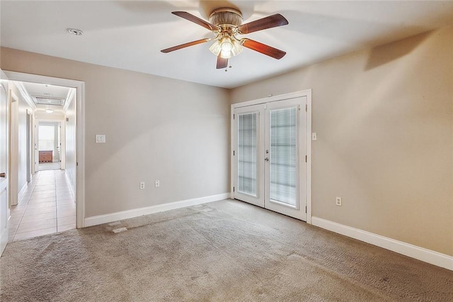 spare room with baseboards, ceiling fan, light colored carpet, attic access, and french doors