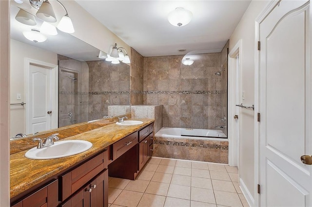 bathroom featuring tile patterned flooring, double vanity, tiled shower / bath, and a sink