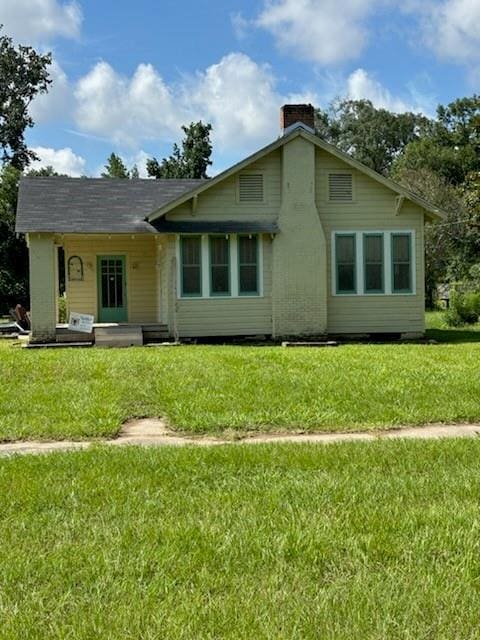 rear view of property with a yard