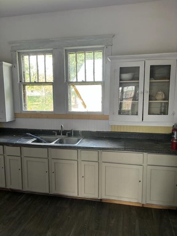 kitchen featuring a healthy amount of sunlight, dark hardwood / wood-style floors, sink, and water heater