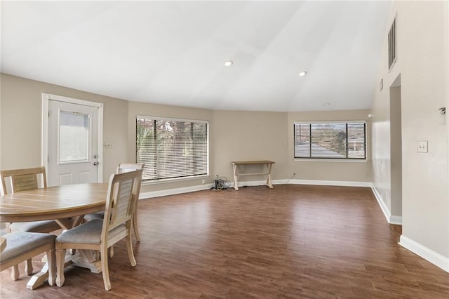 dining area featuring lofted ceiling, a healthy amount of sunlight, and dark wood-type flooring