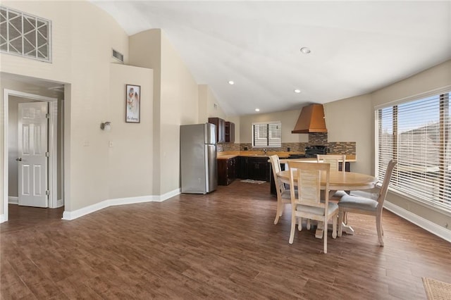 dining area with dark hardwood / wood-style flooring and high vaulted ceiling