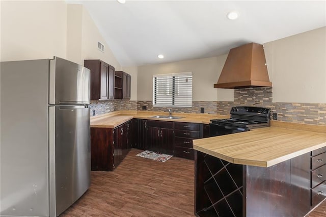 kitchen featuring wooden counters, stainless steel refrigerator, ventilation hood, black / electric stove, and kitchen peninsula