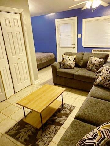 tiled living room featuring ceiling fan