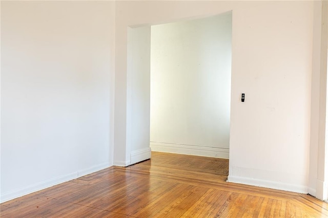 empty room featuring baseboards and hardwood / wood-style floors