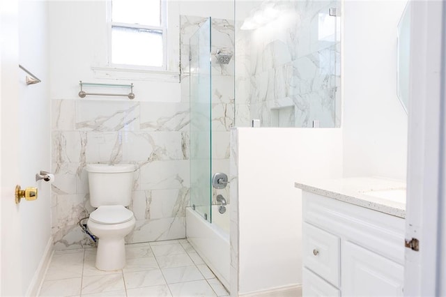 bathroom with toilet, vanity, bathing tub / shower combination, marble finish floor, and tile walls