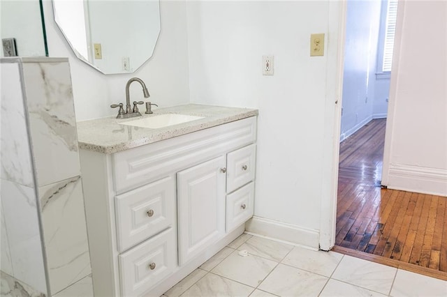 bathroom featuring marble finish floor, vanity, and baseboards