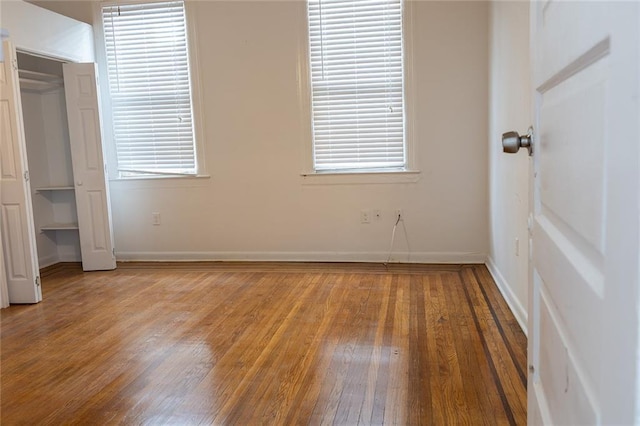 unfurnished bedroom with light wood-style flooring, baseboards, and a closet