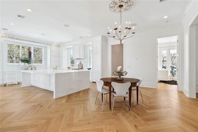 dining area featuring light parquet floors, crown molding, a healthy amount of sunlight, and a notable chandelier