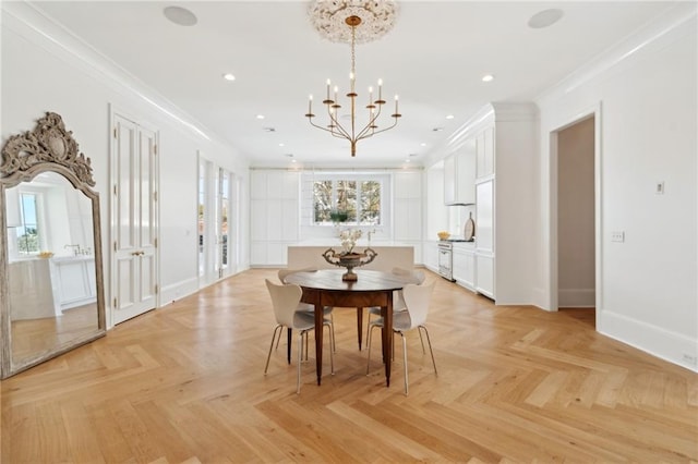 dining room featuring an inviting chandelier, crown molding, and light parquet flooring