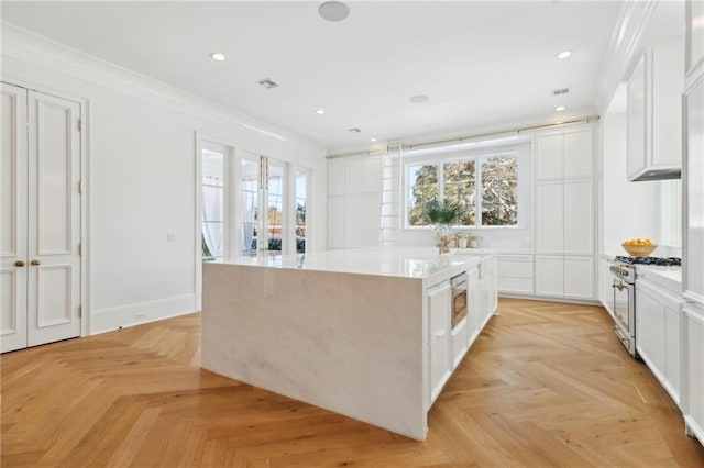 kitchen with a kitchen island, white cabinets, and appliances with stainless steel finishes