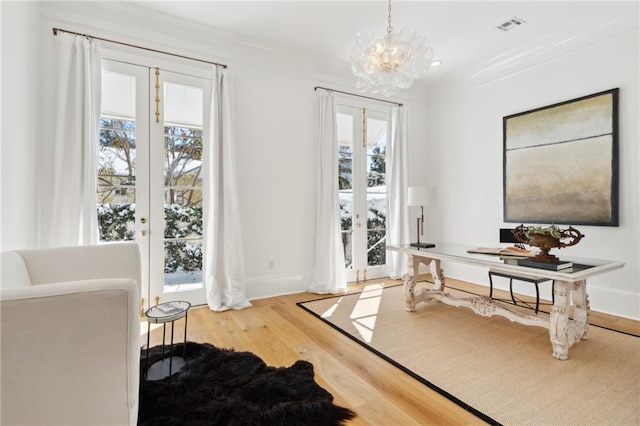 entryway with an inviting chandelier, crown molding, and wood-type flooring