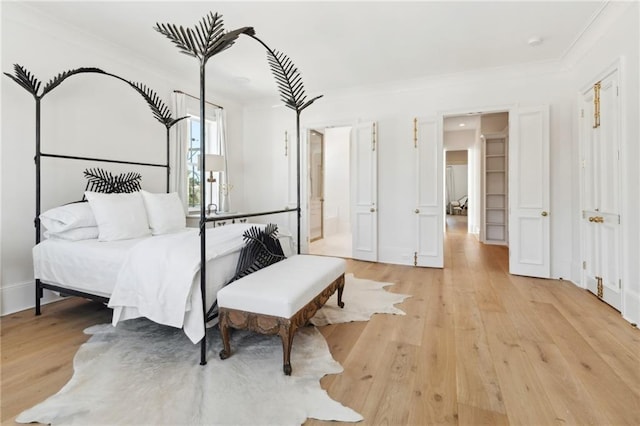 bedroom with crown molding and light hardwood / wood-style floors