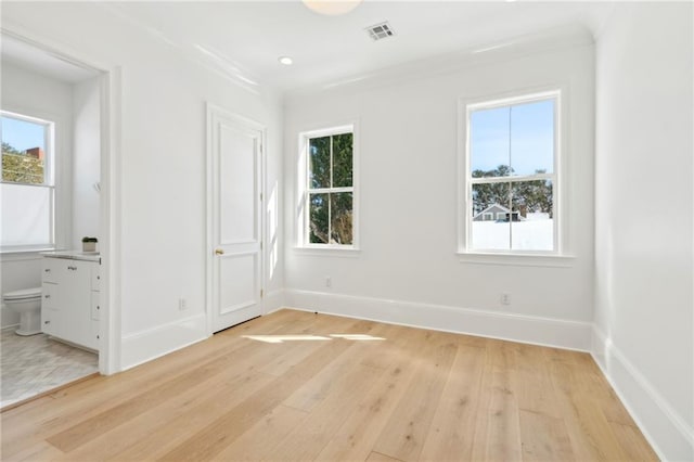 unfurnished bedroom featuring multiple windows and light hardwood / wood-style flooring