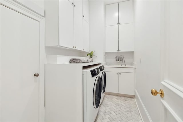 laundry area featuring cabinets, washing machine and dryer, and sink