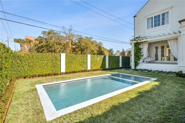 view of swimming pool with a lawn and french doors