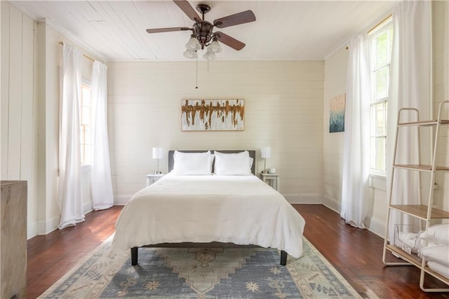 bedroom featuring dark hardwood / wood-style flooring, ornamental molding, and ceiling fan