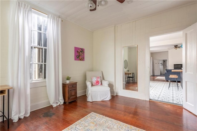 living area featuring ceiling fan and dark hardwood / wood-style flooring