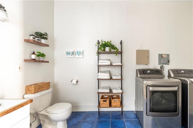 bathroom with tile patterned flooring, vanity, washing machine and clothes dryer, and toilet