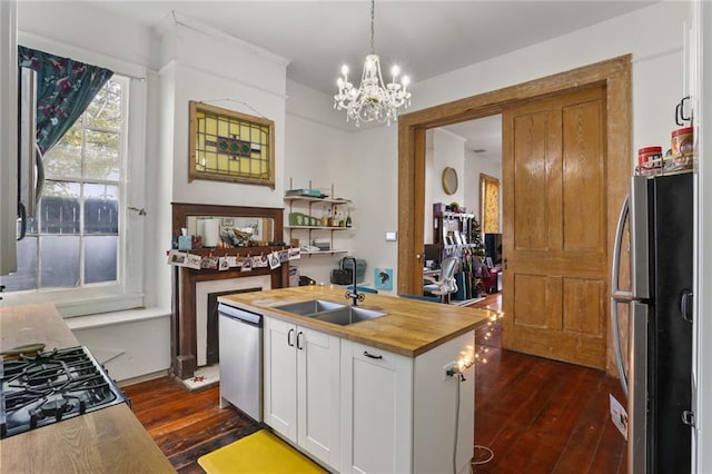 kitchen with sink, hanging light fixtures, a center island with sink, appliances with stainless steel finishes, and white cabinets