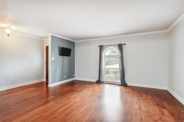 empty room featuring ornamental molding, hardwood / wood-style floors, and a textured ceiling