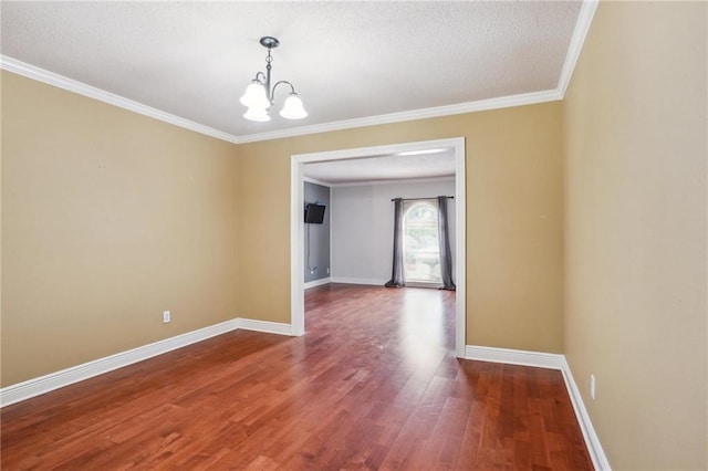 unfurnished dining area with hardwood / wood-style flooring, ornamental molding, a textured ceiling, and an inviting chandelier