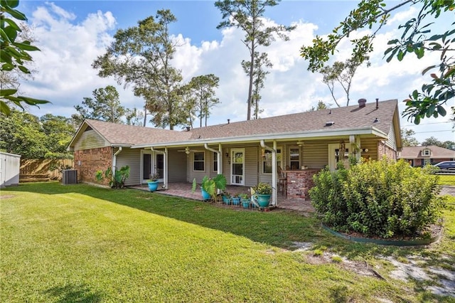 back of house featuring cooling unit, a lawn, and a patio area