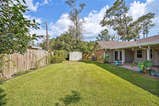 view of yard featuring a shed, central AC, and a patio area