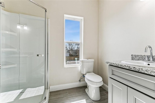 220406 Pauger St, New Orleans, LA 70116 - bathroom with vanity, baseboards, toilet, a stall shower, and wood finished floors