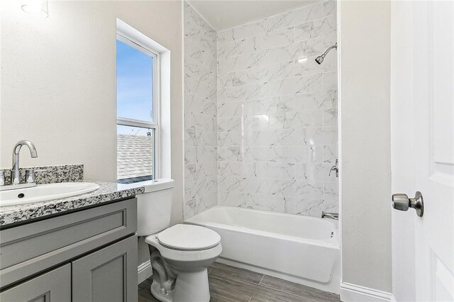 220406 Pauger St, New Orleans, LA 70116 - bathroom with vanity, toilet, washtub / shower combination, wood finished floors, and baseboards