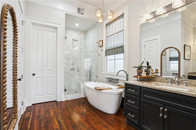 bathroom featuring independent shower and bath, vanity, ornamental molding, and hardwood / wood-style floors