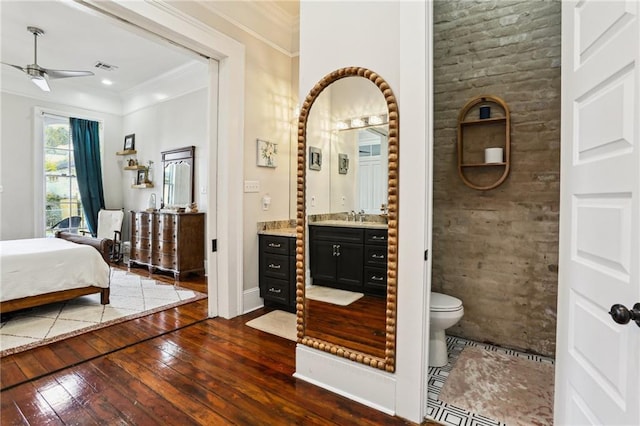 interior space with sink, ceiling fan, dark hardwood / wood-style floors, ensuite bathroom, and ornamental molding