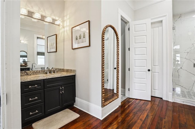 bathroom with vanity, hardwood / wood-style flooring, crown molding, and walk in shower