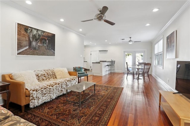 living area featuring recessed lighting, ceiling fan, wood-type flooring, baseboards, and crown molding