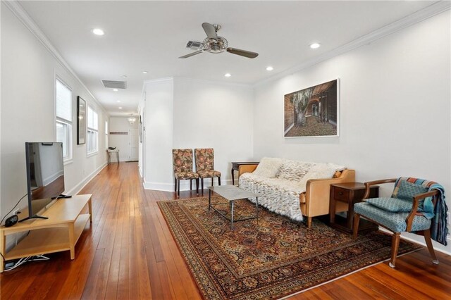 living area with crown molding, hardwood / wood-style flooring, and ceiling fan