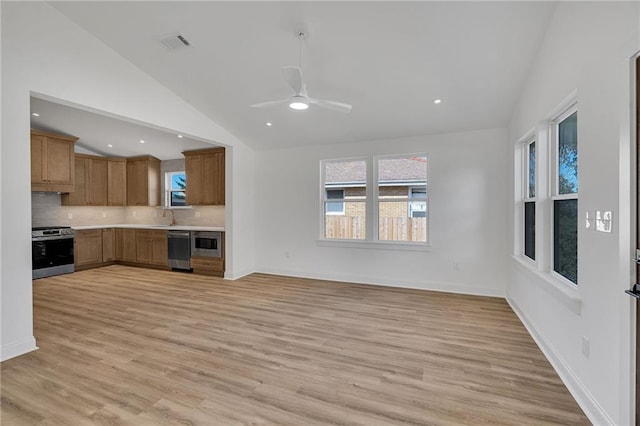 kitchen featuring lofted ceiling, sink, stainless steel appliances, tasteful backsplash, and light hardwood / wood-style floors