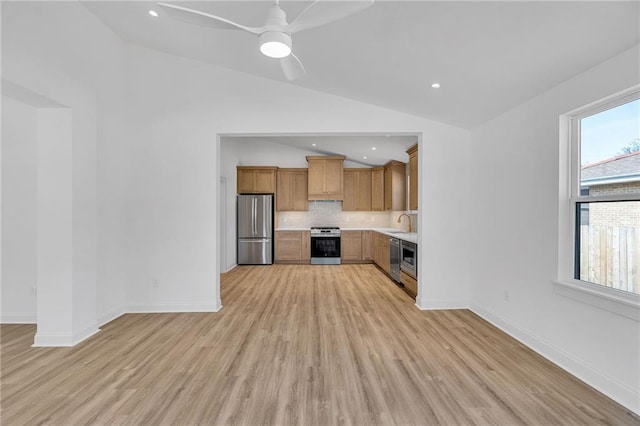 kitchen with sink, backsplash, plenty of natural light, stainless steel appliances, and vaulted ceiling