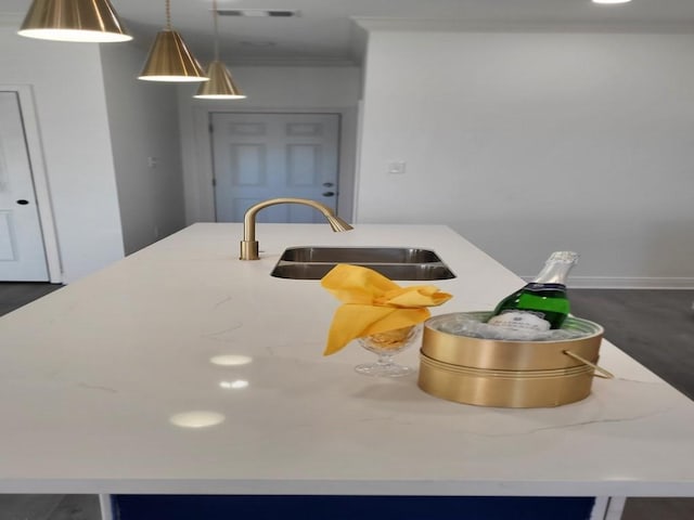 details with pendant lighting, crown molding, a kitchen island with sink, and sink