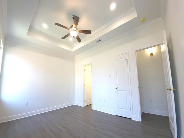 unfurnished bedroom featuring crown molding, ceiling fan, dark hardwood / wood-style floors, and a raised ceiling