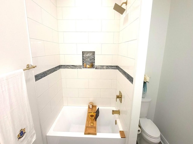 bathroom featuring tiled shower / bath and toilet