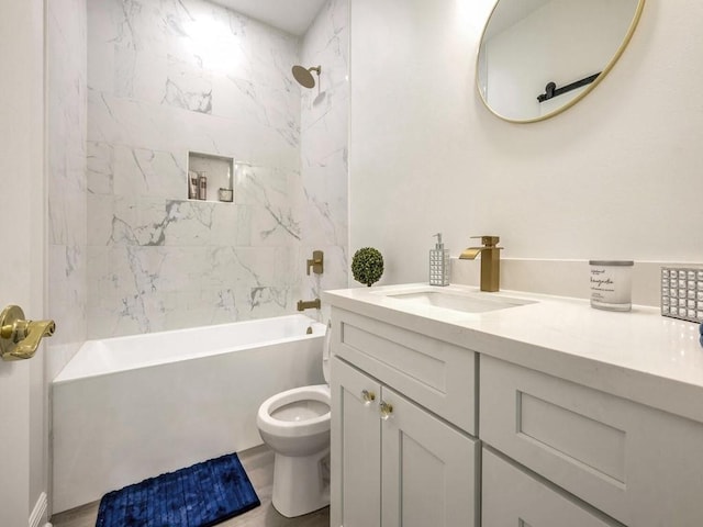 full bathroom featuring tiled shower / bath, vanity, and toilet