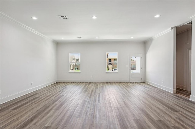 empty room with crown molding and hardwood / wood-style flooring